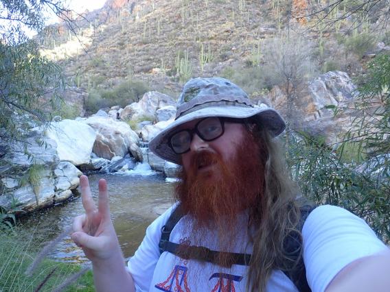 robert morse selfie in a desert scene with a creek behind him